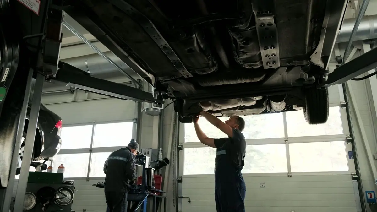 Technicians working under a car on a lift